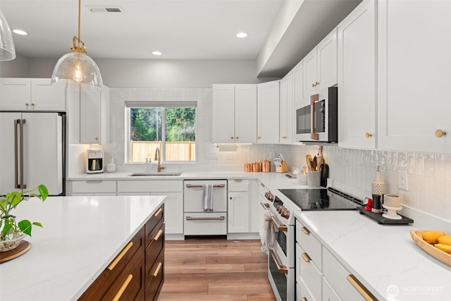 135 Main St E, Packwood, WA 98361 - kitchen featuring white appliances, white cabinets, light wood-style floors, pendant lighting, and decorative backsplash