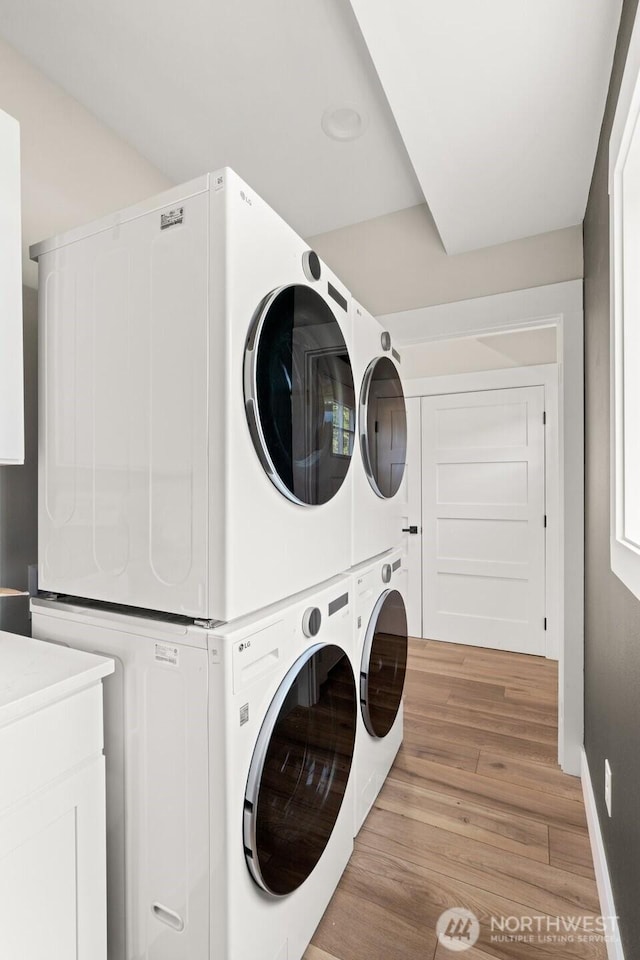 135 Main St E, Packwood, WA 98361 - washroom featuring estacked washer and dryer, light wood-type flooring, independent washer and dryer, and cabinet space