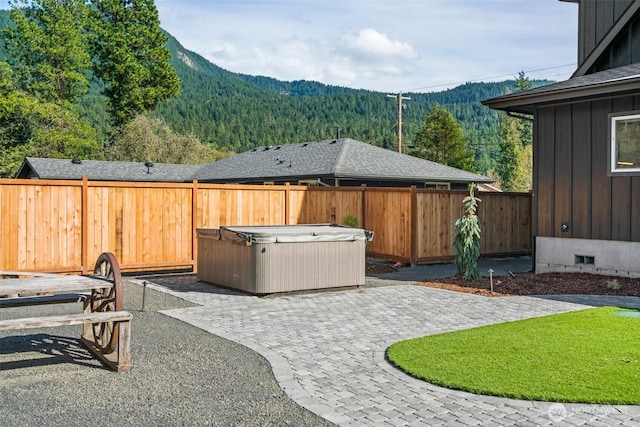 135 Main St E, Packwood, WA 98361 - fenced backyard with a hot tub, a mountain view, a patio area, and a wooded view
