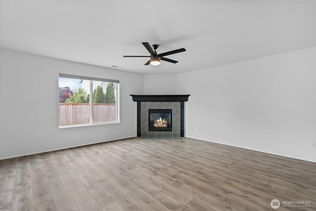 14933 Terra View St SE, Yelm, WA 98597 - unfurnished living room with a ceiling fan, wood finished floors, and a tiled fireplace