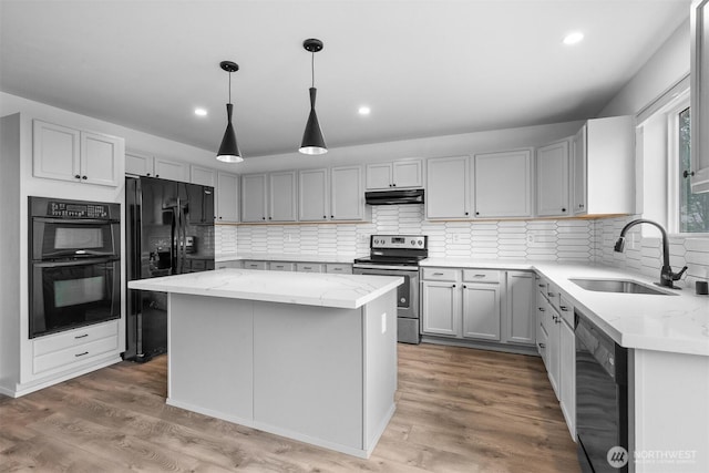 14933 Terra View St SE, Yelm, WA 98597 - kitchen with black appliances, under cabinet range hood, light stone counters, a center island, and tasteful backsplash