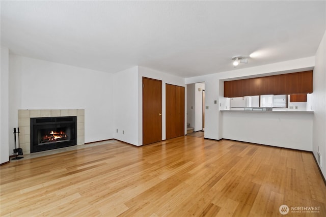 18910 Bothell Everett Hwy Unit K3, Bothell, WA 98012 - unfurnished living room featuring a tile fireplace and light wood-style floors