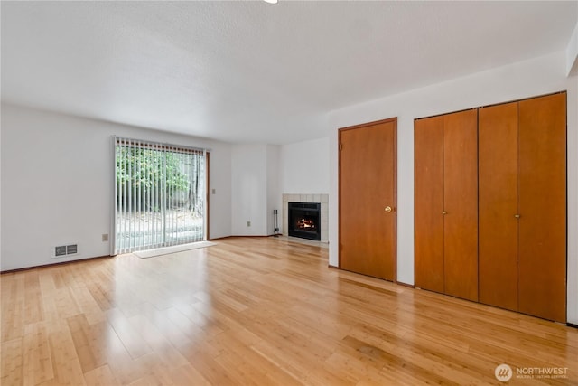 18910 Bothell Everett Hwy Unit K3, Bothell, WA 98012 - unfurnished living room featuring light wood finished floors and a tiled fireplace
