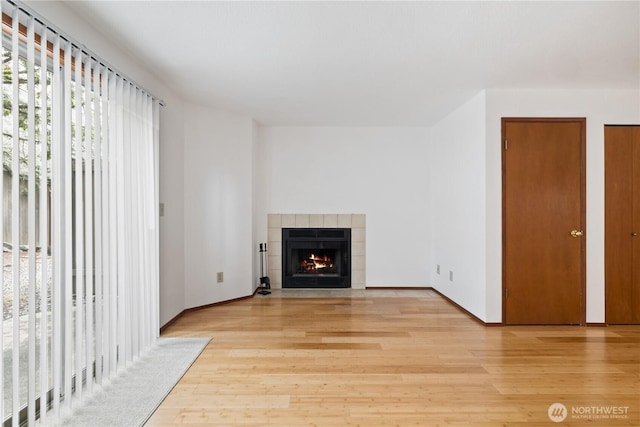 18910 Bothell Everett Hwy Unit K3, Bothell, WA 98012 - unfurnished living room featuring light wood-style floors and a tile fireplace