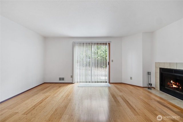 18910 Bothell Everett Hwy Unit K3, Bothell, WA 98012 - unfurnished living room with a tiled fireplace and wood finished floors
