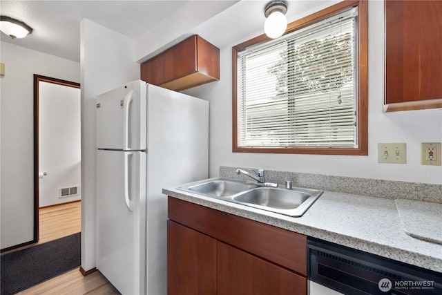 18910 Bothell Everett Hwy Unit K3, Bothell, WA 98012 - kitchen featuring freestanding refrigerator, light countertops, light wood-type flooring, and dishwasher
