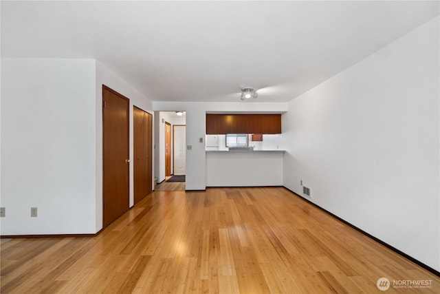 18910 Bothell Everett Hwy Unit K3, Bothell, WA 98012 - unfurnished living room featuring light wood-style floors and baseboards