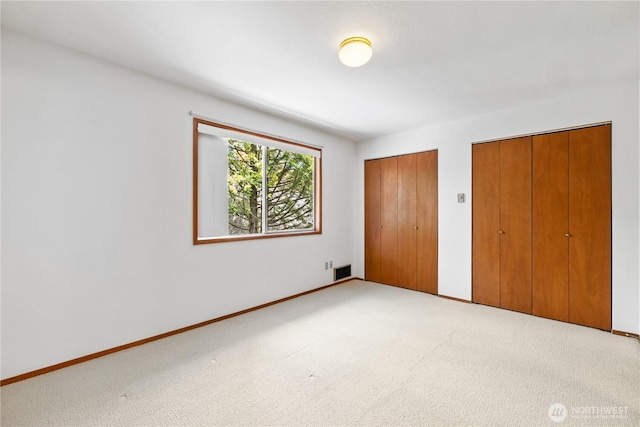 18910 Bothell Everett Hwy Unit K3, Bothell, WA 98012 - unfurnished bedroom featuring multiple closets and light carpet