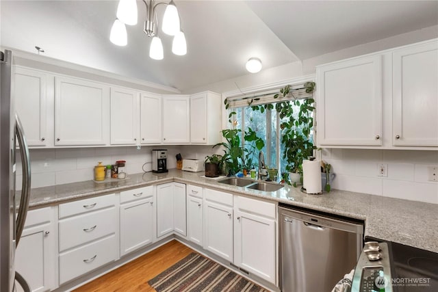 7829 197th Ave E, Bonney Lake, WA 98391 - kitchen with stainless steel appliances, a chandelier, backsplash, white cabinetry, and light wood finished floors