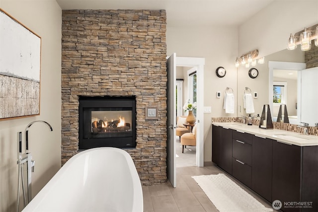 1808 2nd St, Kirkland, WA 98033 - bathroom with double vanity, a freestanding bath, a stone fireplace, and tile patterned floors