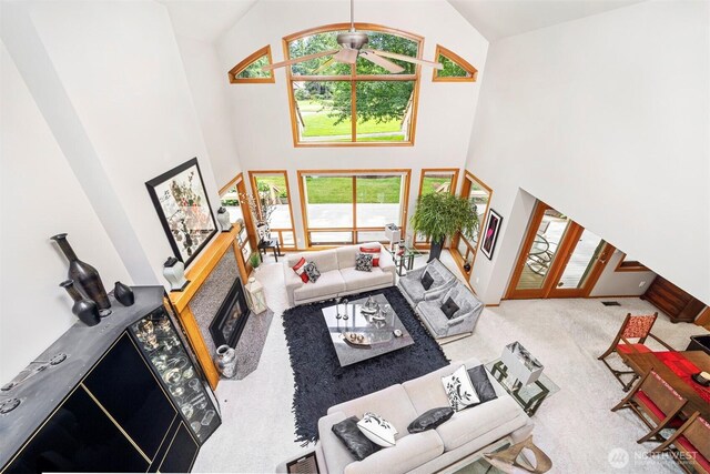 8834 Goldeneye Ln, Blaine, WA 98230 - carpeted living room with a ceiling fan, high vaulted ceiling, and a glass covered fireplace