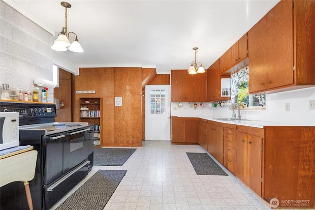 1171 E Mason Lake Dr E, Grapeview, WA 98546 - kitchen with a chandelier, black electric range oven, white microwave, light countertops, and brown cabinets