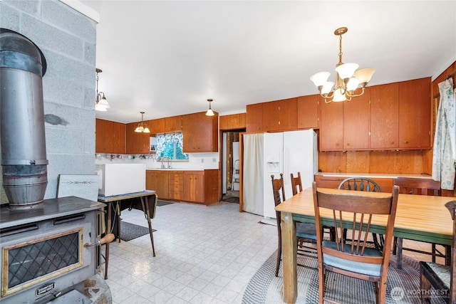 1171 E Mason Lake Dr E, Grapeview, WA 98546 - dining space with a wood stove, a chandelier, and light flooring