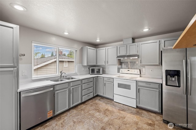 742 N 103rd St, Seattle, WA 98133 - kitchen with appliances with stainless steel finishes, under cabinet range hood, gray cabinetry, backsplash, and recessed lighting
