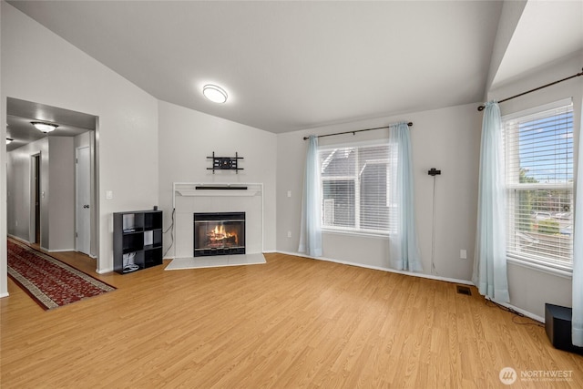 742 N 103rd St, Seattle, WA 98133 - unfurnished living room with lofted ceiling, light wood-style floors, and a fireplace