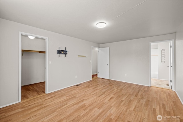 742 N 103rd St, Seattle, WA 98133 - unfurnished bedroom featuring light wood finished floors, a walk in closet, ensuite bathroom, and a closet
