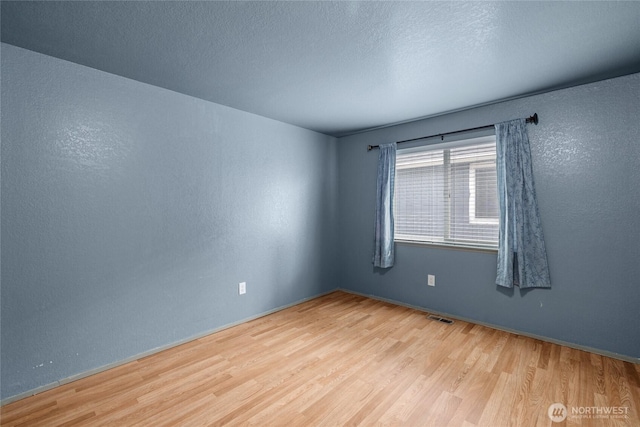 742 N 103rd St, Seattle, WA 98133 - unfurnished room with wood finished floors, a textured wall, and a textured ceiling