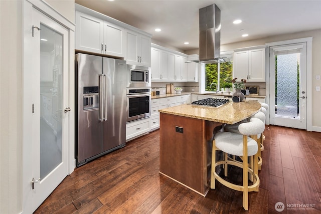17477 NE 123rd Way, Redmond, WA 98052 - kitchen featuring appliances with stainless steel finishes, island range hood, white cabinetry, a kitchen island, and dark wood-type flooring