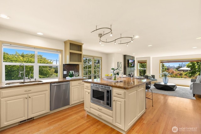 2218 N 38th St, Seattle, WA 98103 - kitchen featuring stainless steel appliances, recessed lighting, light wood finished floors, open floor plan, and stone countertops
