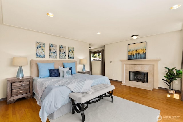 2218 N 38th St, Seattle, WA 98103 - bedroom with wood finished floors, a tiled fireplace, and recessed lighting