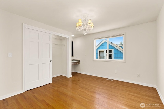 2218 N 38th St, Seattle, WA 98103 - unfurnished bedroom featuring a chandelier, light wood-type flooring, and a closet