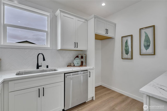 1215 N 10th St, Tacoma, WA 98403 - kitchen with stainless steel dishwasher, white cabinetry, light wood finished floors, light stone counters, and backsplash
