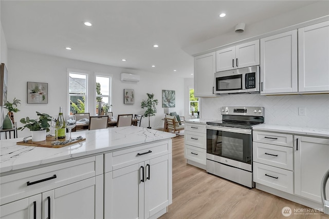 1215 N 10th St, Tacoma, WA 98403 - kitchen featuring stainless steel appliances, light wood finished floors, white cabinetry, tasteful backsplash, and recessed lighting