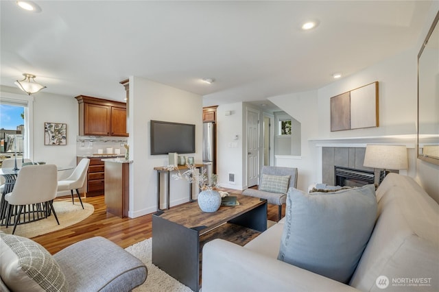 2344 44th Ave SW Unit B, Seattle, WA 98116 - living room with light wood-style flooring, a tile fireplace, and recessed lighting