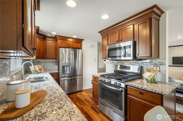 2344 44th Ave SW Unit B, Seattle, WA 98116 - kitchen featuring appliances with stainless steel finishes, tasteful backsplash, dark wood finished floors, light stone countertops, and recessed lighting