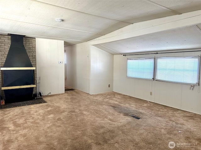 5626 SW 113th Ave E Unit 63, Puyallup, WA 98372 - unfurnished living room featuring carpet floors, a wood stove, and lofted ceiling