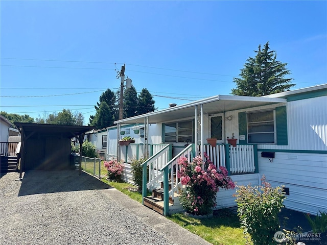 5626 SW 113th Ave E Unit 63, Puyallup, WA 98372 - manufactured / mobile home featuring gravel driveway, covered porch, and a carport