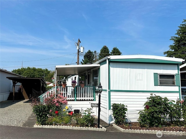 5626 SW 113th Ave E Unit 63, Puyallup, WA 98372 - manufactured / mobile home featuring gravel driveway and a porch