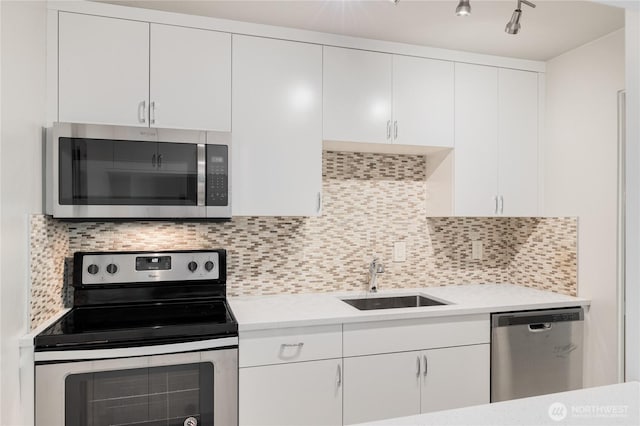 5101 NE 55th St Unit 103, Seattle, WA 98105 - kitchen featuring stainless steel appliances, light countertops, white cabinets, and decorative backsplash