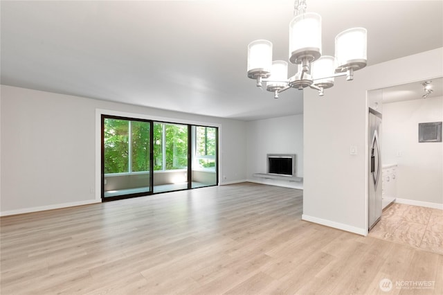 5101 NE 55th St Unit 103, Seattle, WA 98105 - unfurnished living room with light wood-style floors, a chandelier, and a fireplace with raised hearth
