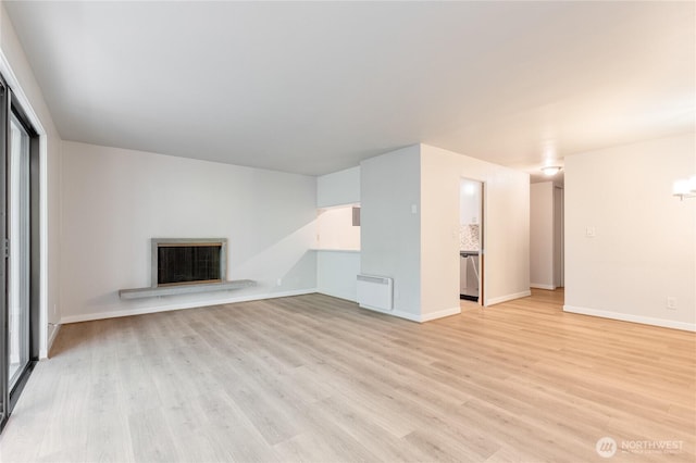 5101 NE 55th St Unit 103, Seattle, WA 98105 - unfurnished living room with light wood-style floors and a fireplace with raised hearth