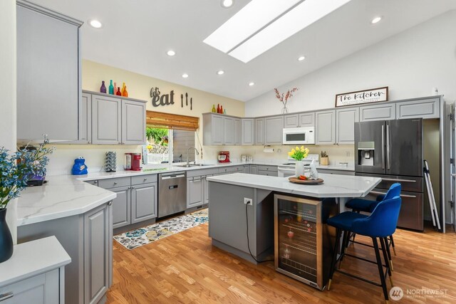 2615 N Baker Ave, East Wenatchee, WA 98802 - kitchen with gray cabinetry, stainless steel appliances, wine cooler, a kitchen island, and light wood-type flooring