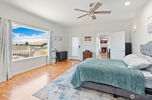 2615 N Baker Ave, East Wenatchee, WA 98802 - bedroom featuring wood finished floors, a lit fireplace, a ceiling fan, and recessed lighting