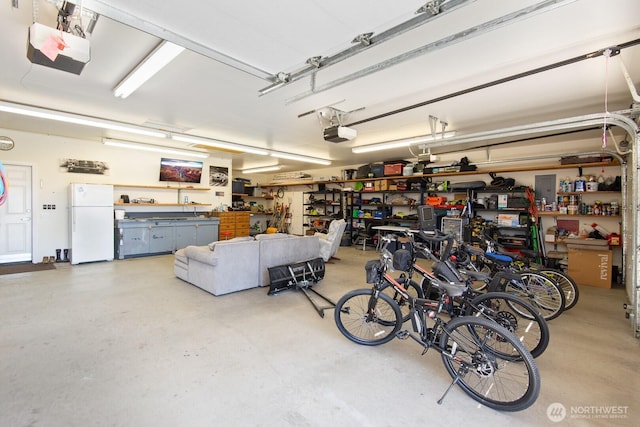 2615 N Baker Ave, East Wenatchee, WA 98802 - garage with freestanding refrigerator, a workshop area, a garage door opener, and electric panel