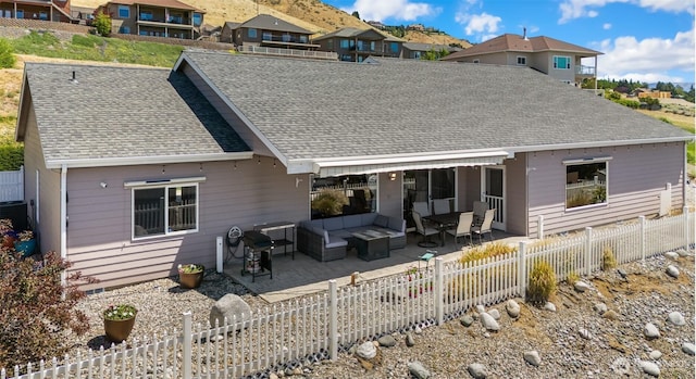 2615 N Baker Ave, East Wenatchee, WA 98802 - back of property featuring an outdoor living space, a fenced backyard, a patio area, and a shingled roof