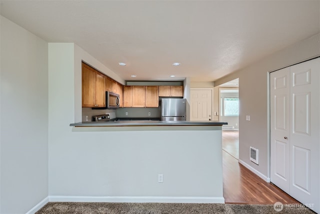 26339 116th Ave SE Unit I202, Kent, WA 98030 - kitchen featuring appliances with stainless steel finishes, a peninsula, recessed lighting, and brown cabinets