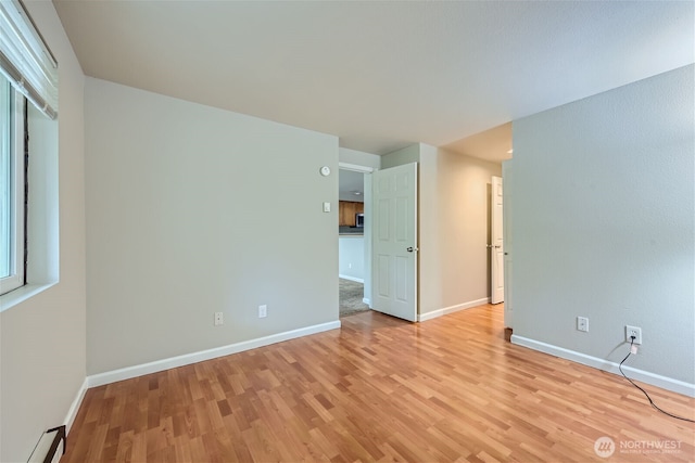 26339 116th Ave SE Unit I202, Kent, WA 98030 - empty room with light wood-type flooring and a baseboard radiator