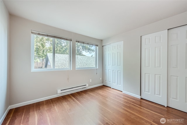 26339 116th Ave SE Unit I202, Kent, WA 98030 - unfurnished bedroom with baseboard heating, two closets, and light wood finished floors
