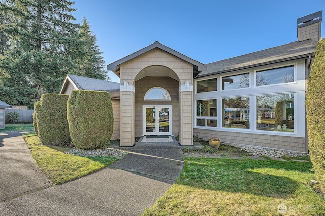 26339 116th Ave SE Unit I202, Kent, WA 98030 - view of exterior entry with a chimney, french doors, and roof with shingles