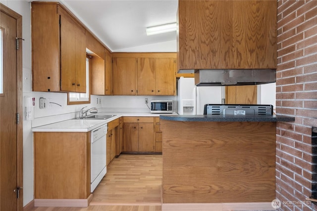 22223 10th Ave S, Des Moines, WA 98198 - kitchen with white dishwasher, stainless steel microwave, vaulted ceiling, light wood finished floors, and brown cabinets