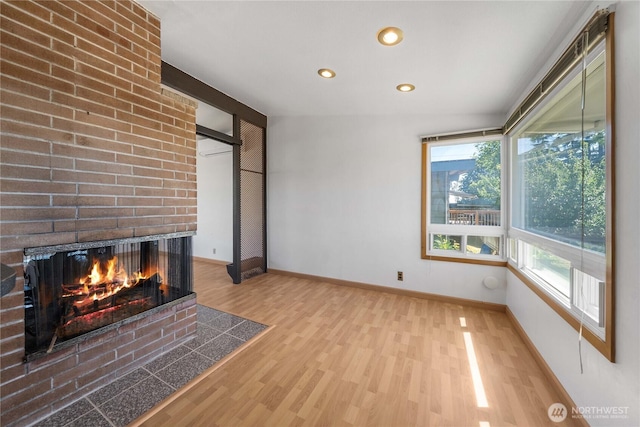 22223 10th Ave S, Des Moines, WA 98198 - unfurnished living room featuring wood finished floors, a brick fireplace, and recessed lighting