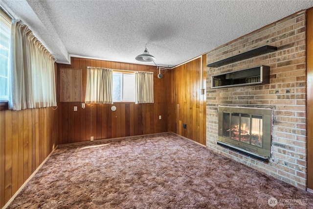 22223 10th Ave S, Des Moines, WA 98198 - unfurnished living room with wood walls, a brick fireplace, a textured ceiling, and carpet flooring