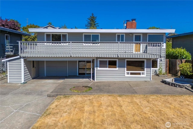 22223 10th Ave S, Des Moines, WA 98198 - view of front of home featuring a chimney, an attached garage, concrete driveway, and a balcony