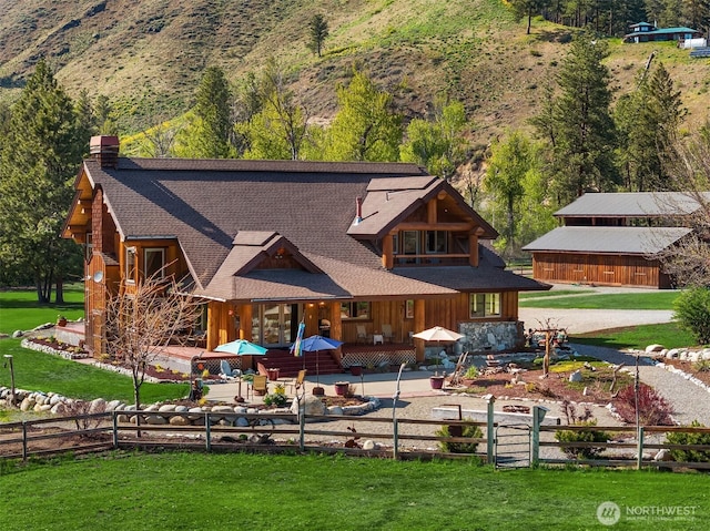 639 A Twisp River Rd, Twisp, WA 98856 - back of house with a chimney, a fenced front yard, a shingled roof, and a porch
