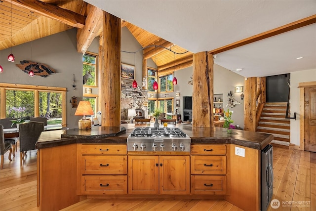 639 A Twisp River Rd, Twisp, WA 98856 - kitchen with stainless steel gas cooktop, light wood-type flooring, open floor plan, decorative columns, and a stone fireplace