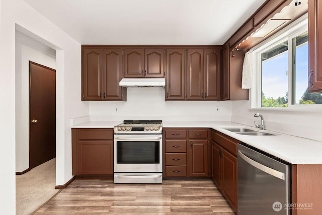 6114 47th Street Ct W, University Place, WA 98466 - kitchen featuring stainless steel appliances, under cabinet range hood, light countertops, and light wood-style floors